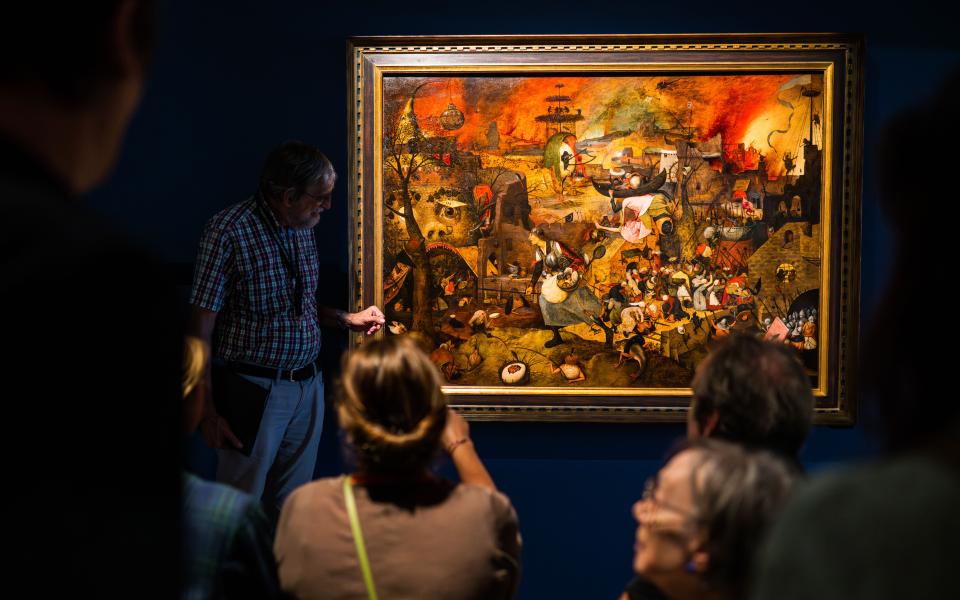 Mensen kijken naar het schilderij 'Dulle Griet' van Pieter Bruegel de Oude.